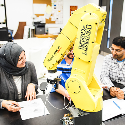 3 students surrounding a robot